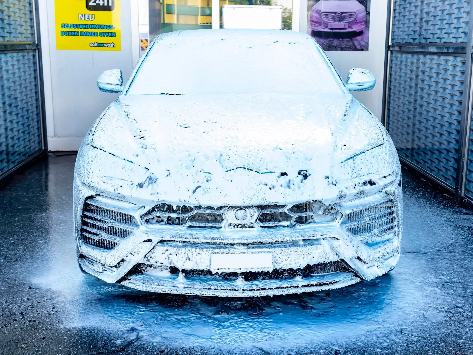 A car covered in white foam at a car wash. A car covered in white foam at a car wash.