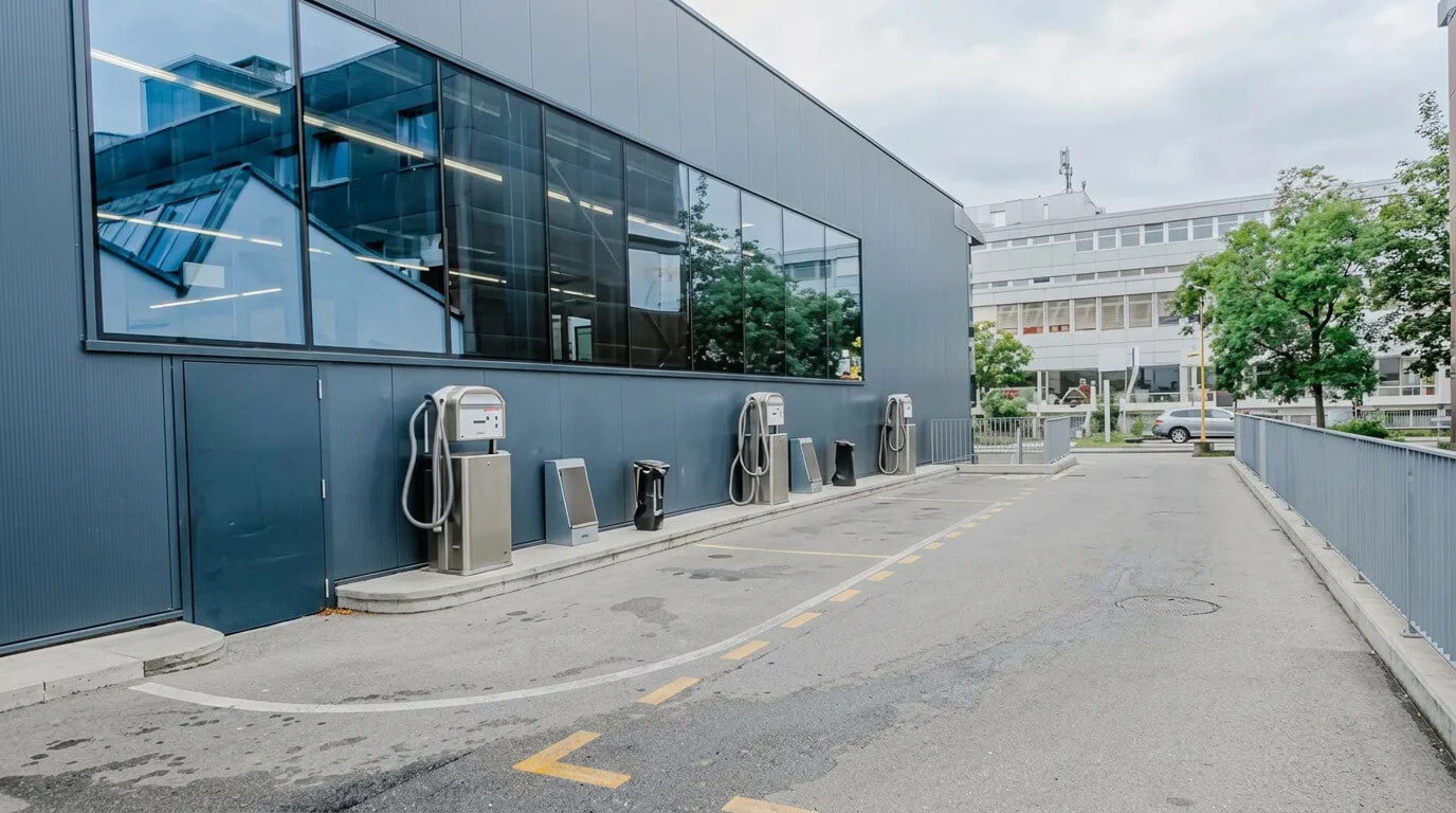 Stazioni di ricarica per veicoli elettrici accanto a un edificio moderno in una strada vuota. Stazioni di ricarica per veicoli elettrici accanto a un edificio moderno in una strada vuota.